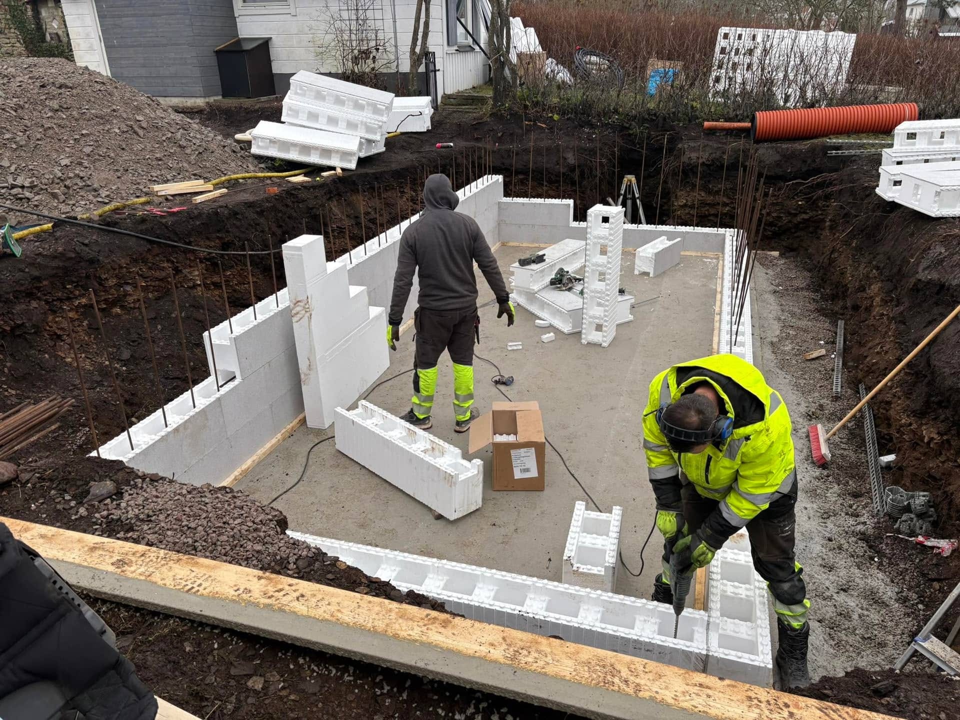 Arbetare bygger husgrund med ICF-block