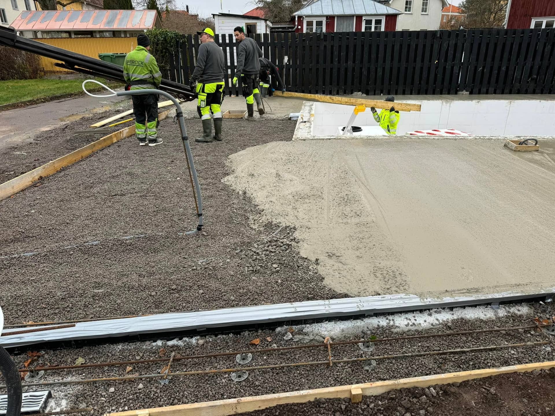 Arbetare gjuter betong runt pool