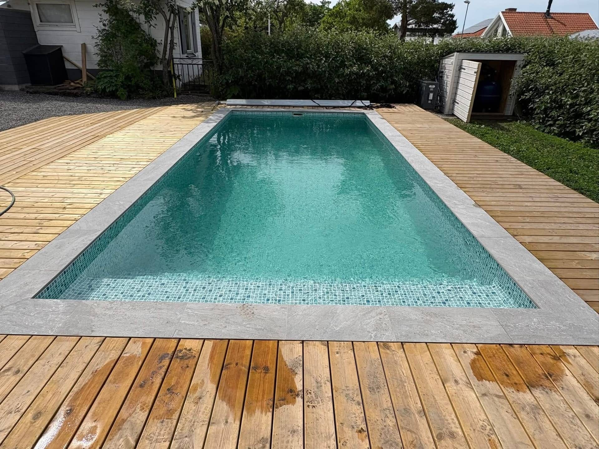 Färdig pool med mosaik, stenkant och trädäck