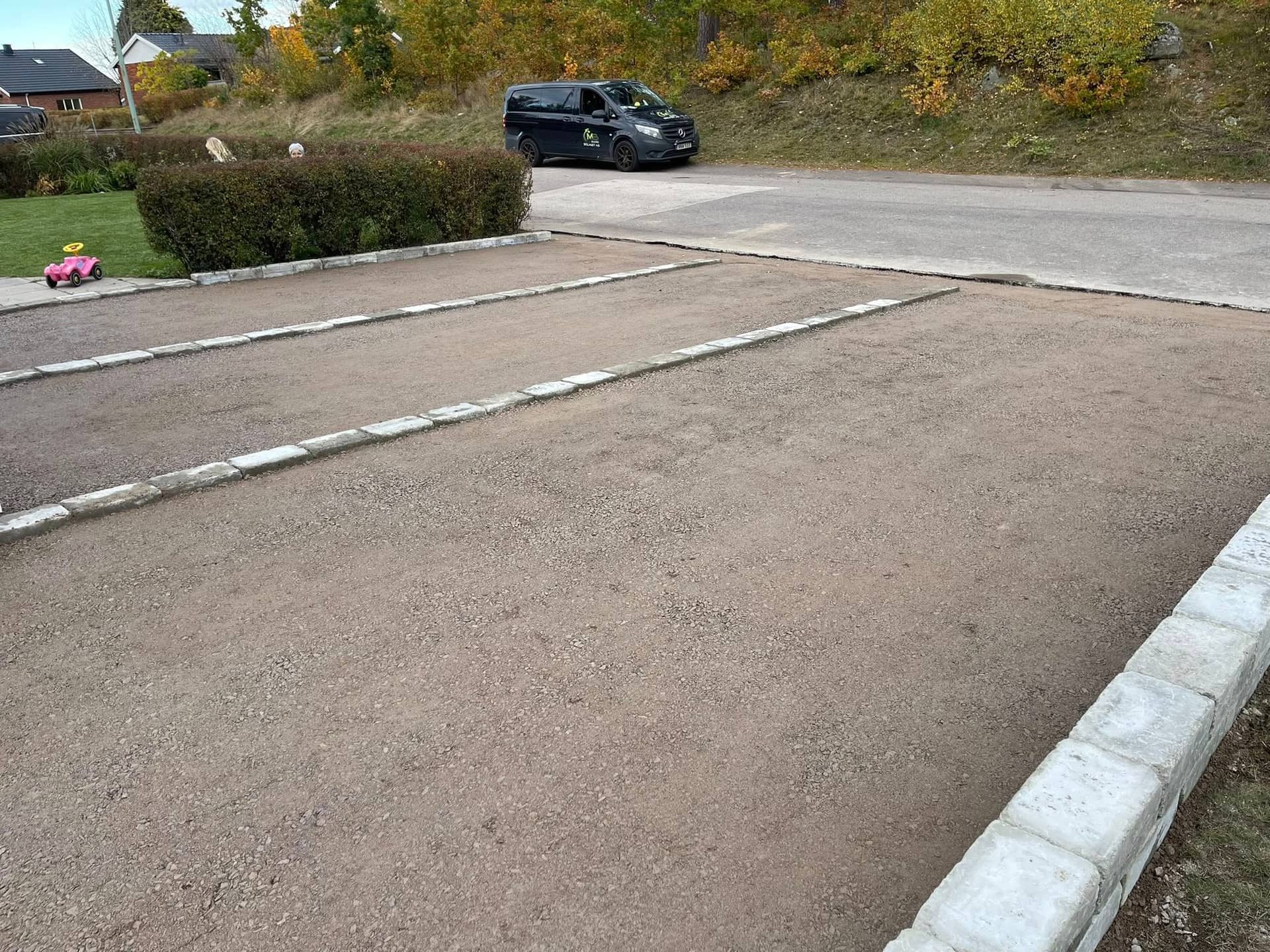 Stenlagd uppfart med företagsbil på plats
